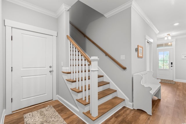 stairs with hardwood / wood-style floors and ornamental molding