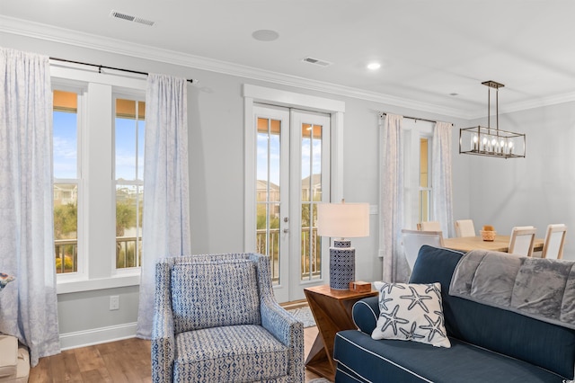 sitting room with french doors, ornamental molding, light hardwood / wood-style floors, and a notable chandelier