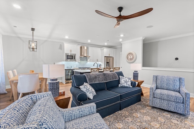 living room featuring ornamental molding, ceiling fan, and light hardwood / wood-style floors