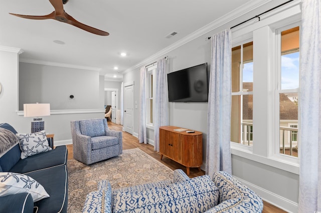 living room featuring hardwood / wood-style flooring, ceiling fan, and ornamental molding