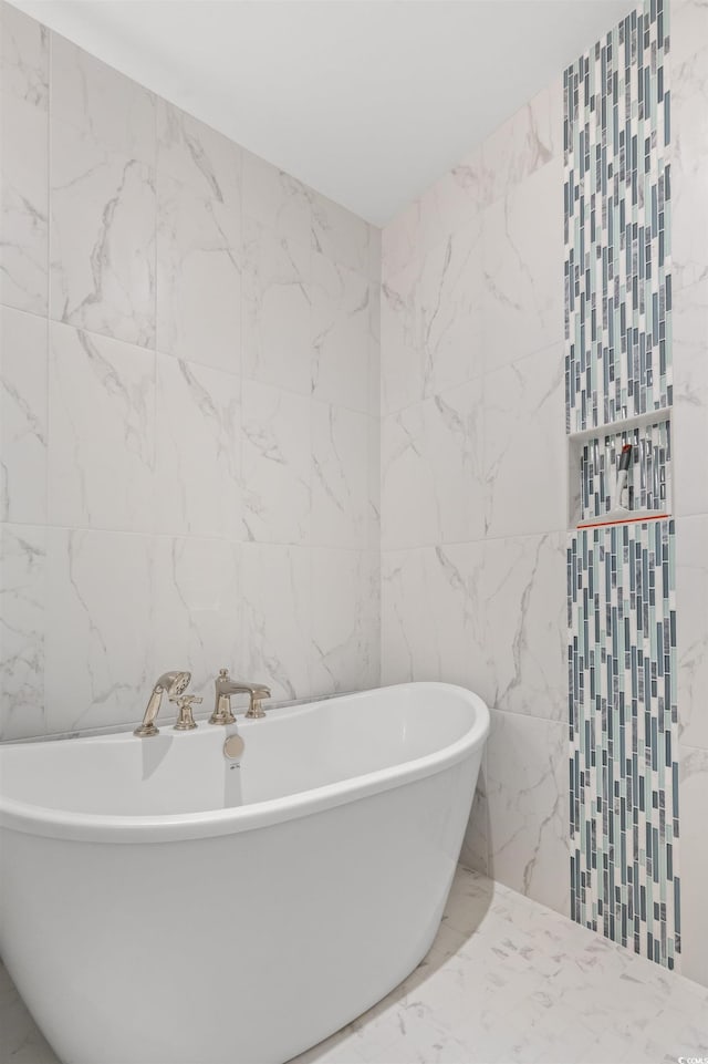 bathroom with tile walls and a tub