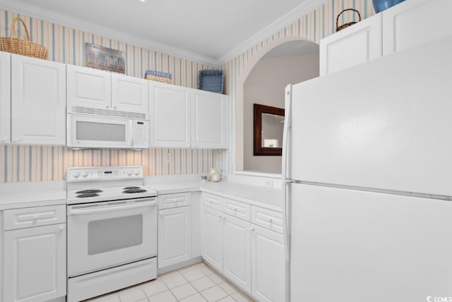 kitchen featuring white appliances, ornamental molding, light tile patterned floors, and white cabinets