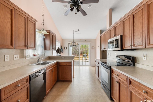 kitchen featuring a sink, hanging light fixtures, light countertops, brown cabinets, and black appliances