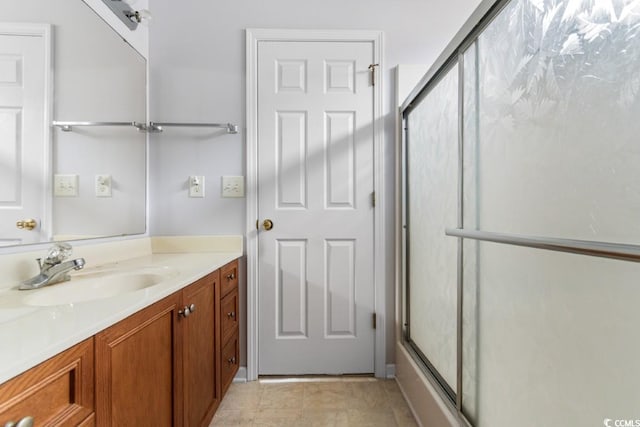 bathroom with a shower with door and vanity