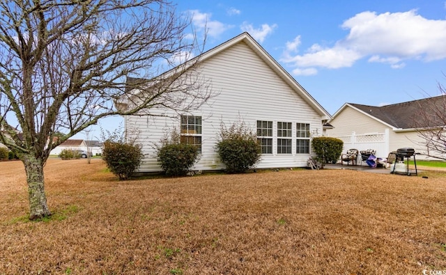 view of side of property featuring a yard and a patio