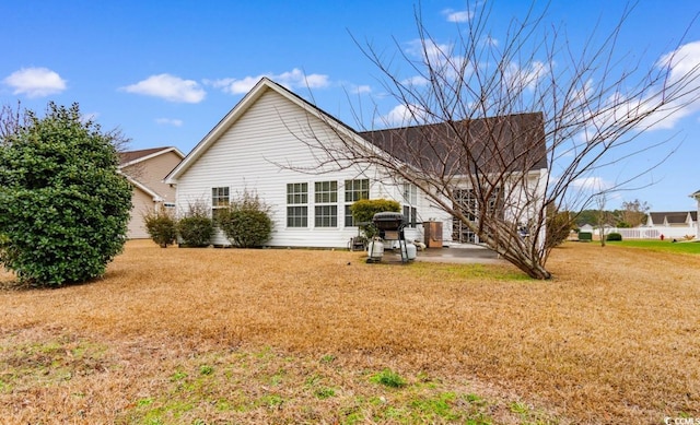 back of house featuring a patio area and a lawn