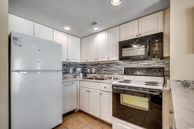 kitchen featuring sink, white appliances, white cabinetry, tasteful backsplash, and light tile patterned flooring