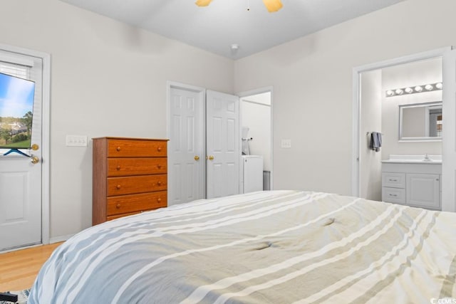 bedroom featuring ensuite bathroom, hardwood / wood-style flooring, ceiling fan, and sink