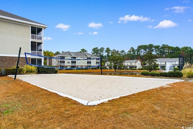 view of community with a lawn and volleyball court