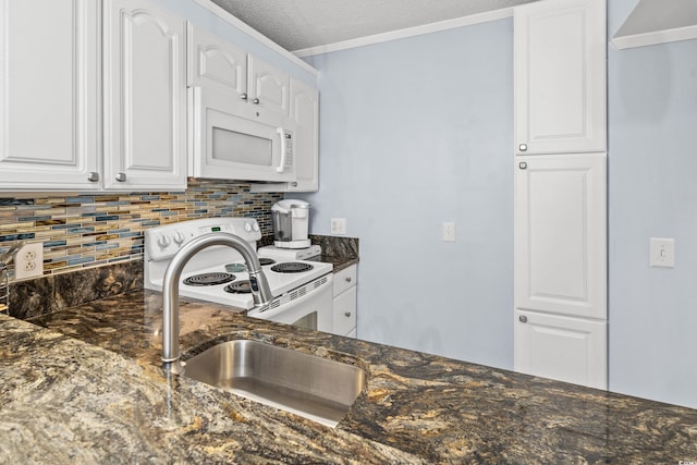 kitchen with dark stone counters, white appliances, white cabinetry, and decorative backsplash