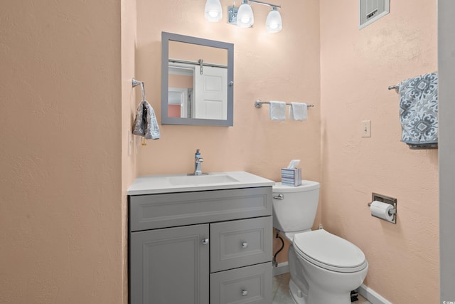 bathroom with a textured wall, toilet, visible vents, vanity, and baseboards