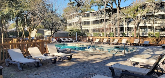 community pool featuring fence and a patio