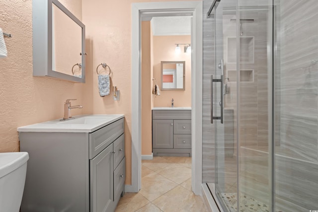 bathroom with a stall shower, a textured wall, vanity, and tile patterned floors