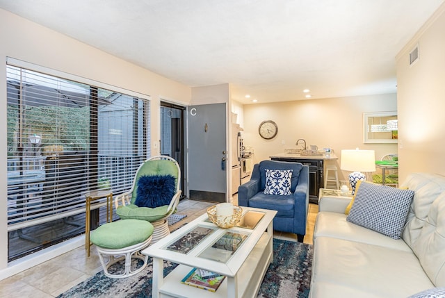 living room with a healthy amount of sunlight, sink, and light tile patterned floors