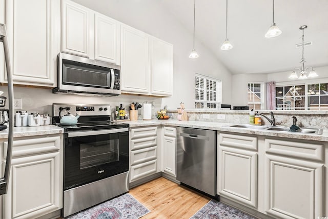 kitchen with sink, decorative light fixtures, stainless steel appliances, light hardwood / wood-style floors, and white cabinets