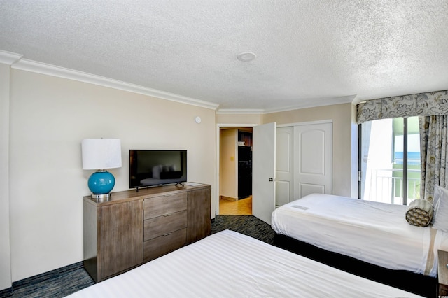 bedroom with a textured ceiling, ornamental molding, a closet, and freestanding refrigerator