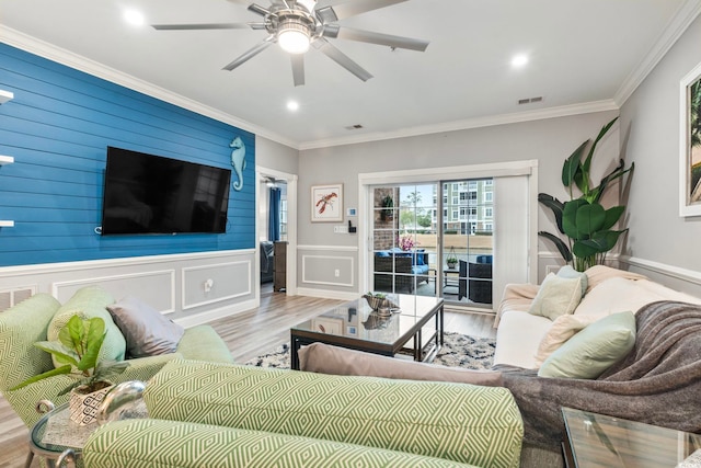 living room featuring crown molding, light hardwood / wood-style floors, and ceiling fan