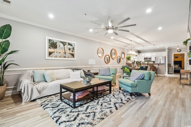 living room with crown molding, light hardwood / wood-style flooring, and ceiling fan