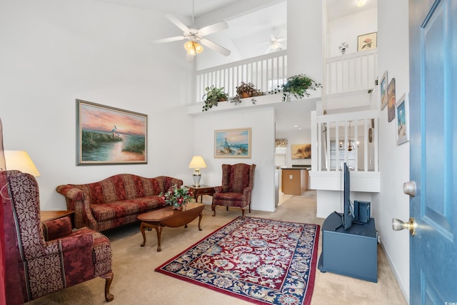 living room with light carpet, ceiling fan, and a towering ceiling