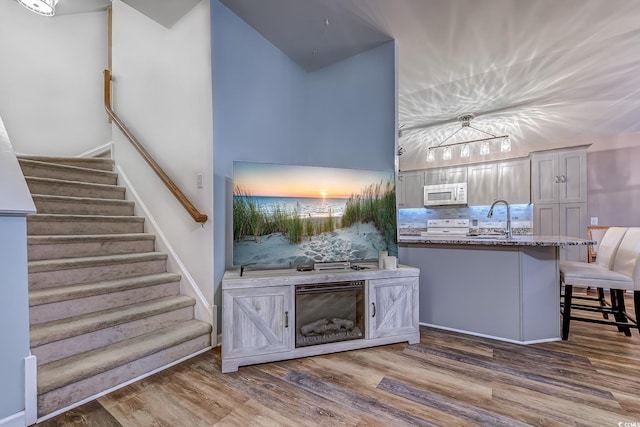 920 Leather Leaf Ln, Longs, SC 29568 - bar featuring white microwave, a sink, wood finished floors, stairs, and range with electric stovetop