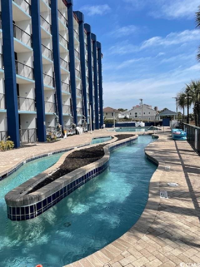 view of swimming pool featuring a hot tub