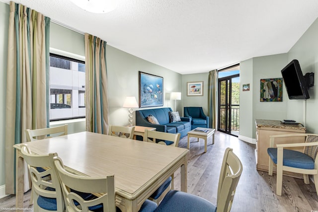 dining area with light hardwood / wood-style floors and a textured ceiling