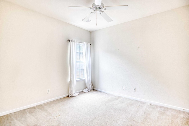 empty room featuring light carpet, a ceiling fan, and baseboards