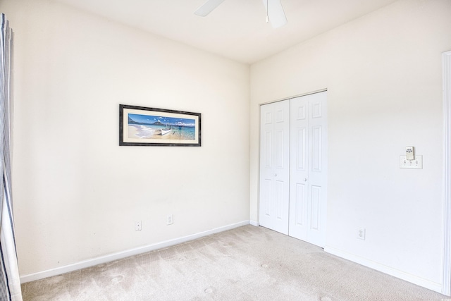 unfurnished bedroom featuring a closet, light carpet, and baseboards