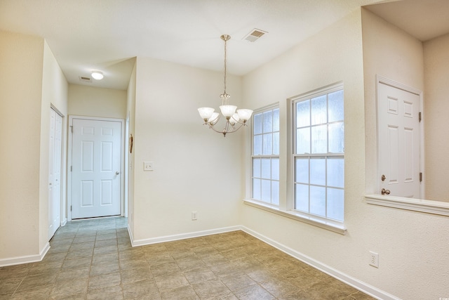 unfurnished dining area with baseboards, visible vents, and a chandelier