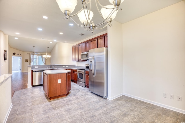 kitchen featuring appliances with stainless steel finishes, a peninsula, hanging light fixtures, light countertops, and a chandelier