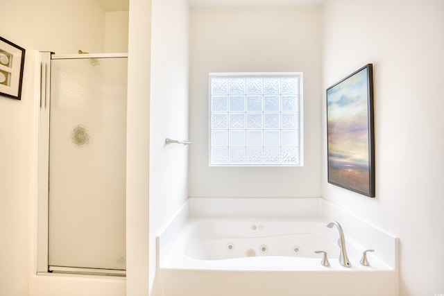 bathroom featuring a jetted tub and a shower stall