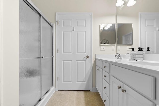 bathroom with vanity and a shower with shower door