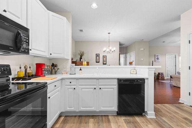 kitchen featuring hanging light fixtures, black appliances, kitchen peninsula, and white cabinets