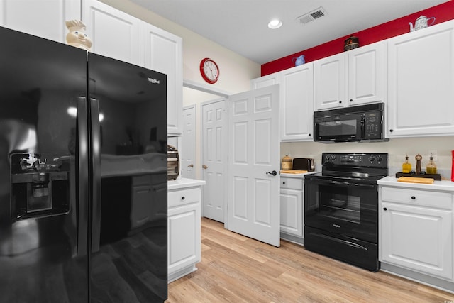 kitchen with white cabinetry, black appliances, and light wood-type flooring