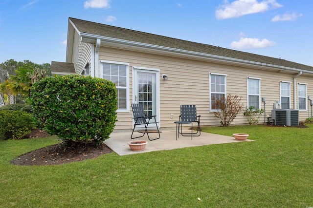 rear view of property with central AC unit, a patio area, and a lawn