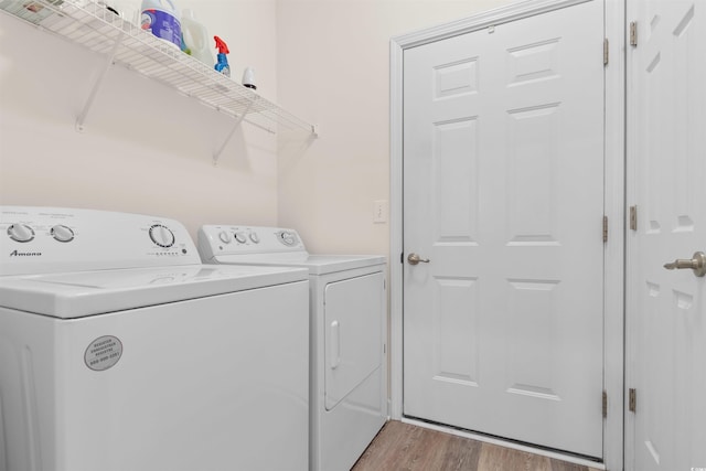 laundry room with washer and clothes dryer and light hardwood / wood-style flooring