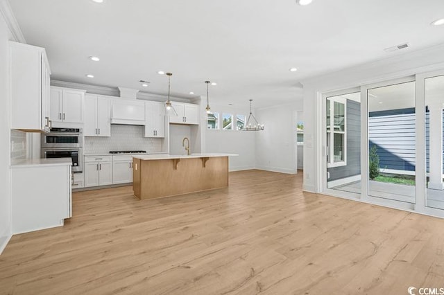 1800 Tryon Dr, Myrtle Beach, SC 29588 - kitchen featuring double oven, baseboards, light wood-style flooring, backsplash, and white cabinetry