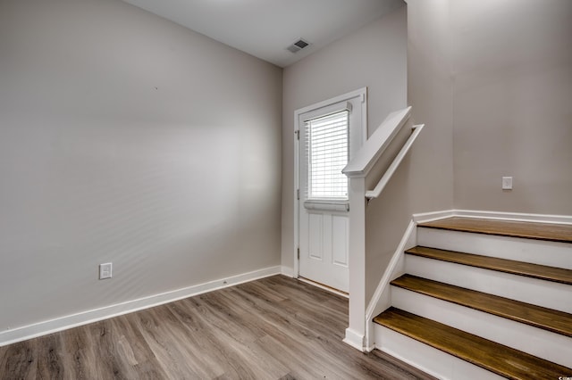 stairs featuring wood finished floors, visible vents, and baseboards