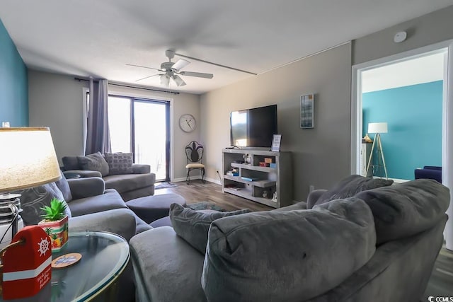 living room featuring ceiling fan, baseboards, and wood finished floors