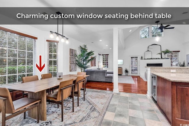 dining room featuring wine cooler, ceiling fan, high vaulted ceiling, and a wealth of natural light