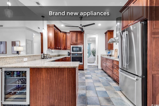 kitchen featuring sink, appliances with stainless steel finishes, kitchen peninsula, pendant lighting, and beverage cooler