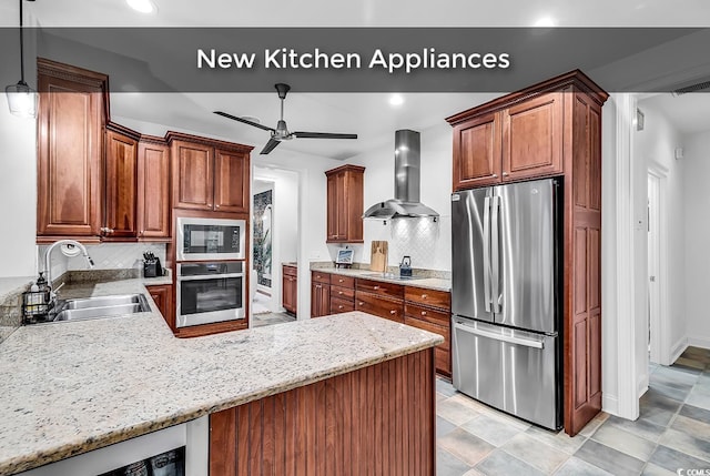 kitchen featuring decorative light fixtures, sink, decorative backsplash, black appliances, and wall chimney range hood