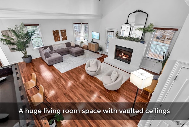 living room with a towering ceiling and hardwood / wood-style floors