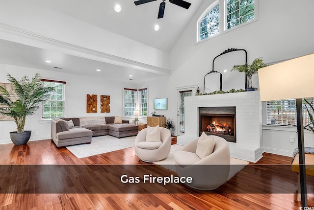 living room featuring plenty of natural light, hardwood / wood-style floors, and a brick fireplace