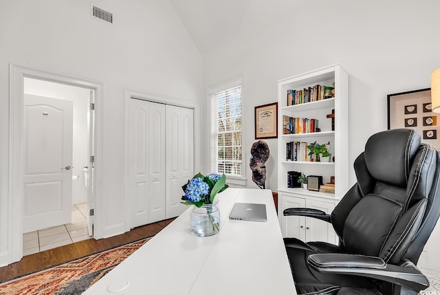 office featuring lofted ceiling and dark hardwood / wood-style flooring