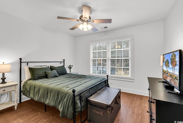 bedroom with dark hardwood / wood-style floors and ceiling fan