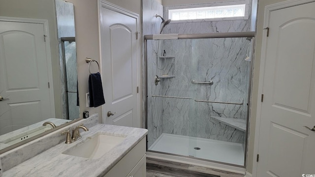 bathroom with hardwood / wood-style flooring, vanity, and walk in shower