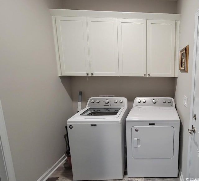 laundry room with cabinets and washing machine and clothes dryer