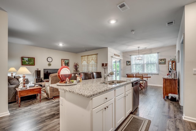 kitchen with white cabinets, dishwasher, an island with sink, open floor plan, and decorative light fixtures