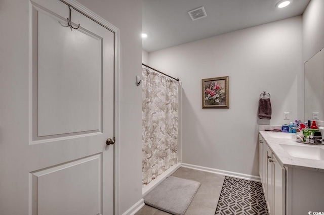 bathroom with double vanity, recessed lighting, visible vents, a sink, and baseboards